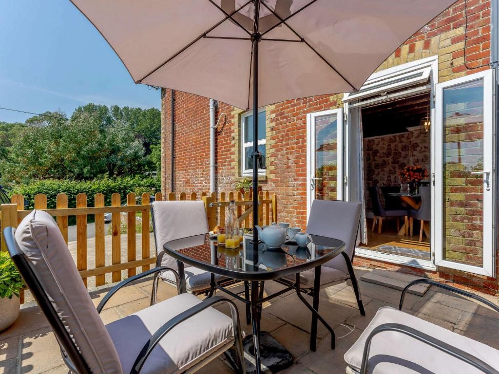 un tavolo e sedie con ombrellone su un patio di 2 bed property in Ventnor 82973 a Wroxall