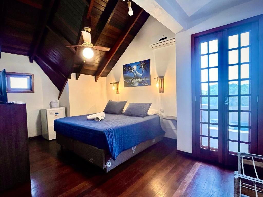 um quarto com uma cama com lençóis azuis e um tecto em Pousada Canajurê em Florianópolis
