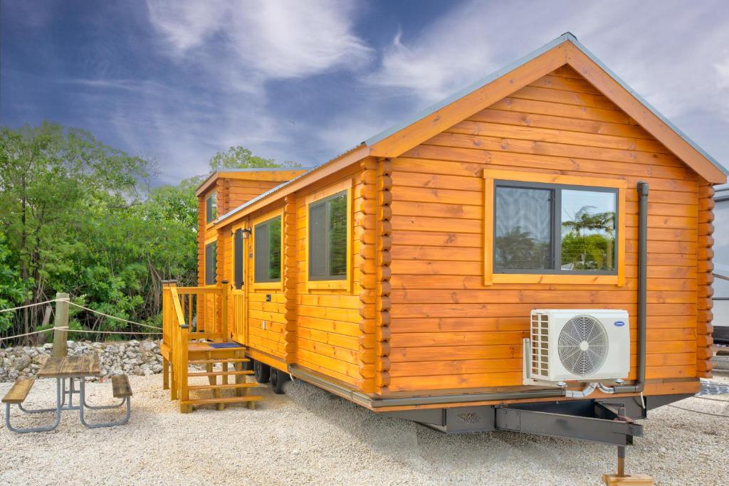 a wooden cabin with a window and a fan at Cabins at Bonefish Bay in Marathon