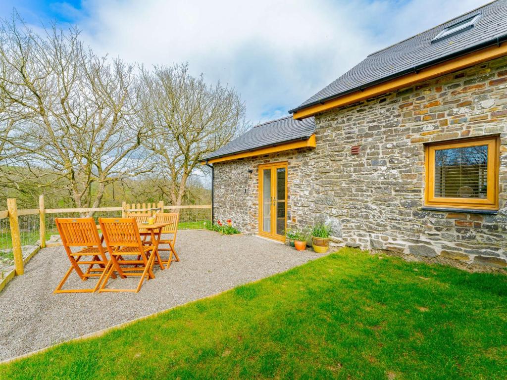 a stone house with two chairs and a table at 1 Bed in Aberystwyth 83551 in Llanilar