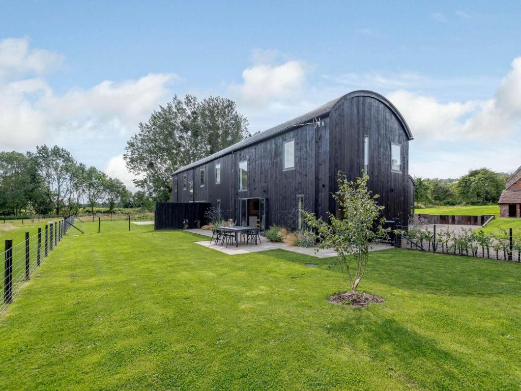 a black barn with a green yard in front of it at 3 Bed in Ludlow 83865 in Lane to Richards Castle