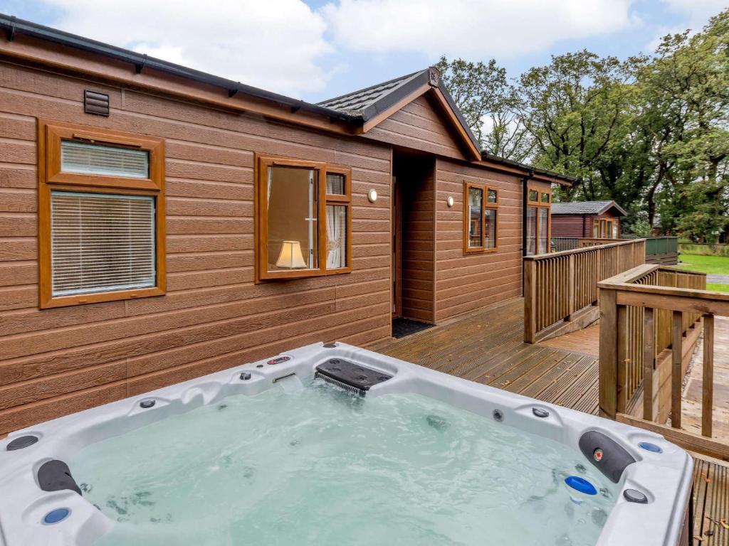 a hot tub on a deck next to a house at 2 Bed in Okehampton 85432 in Okehampton