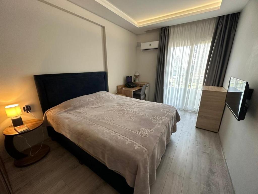 a hotel room with a bed and a window at Flat near the sea in Erdemli