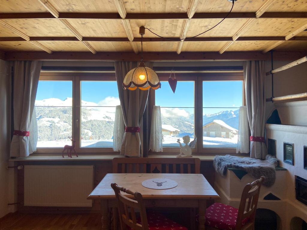 a dining room with a table and some windows at Blick Tirol direkt auf der Skipiste in Mittersill