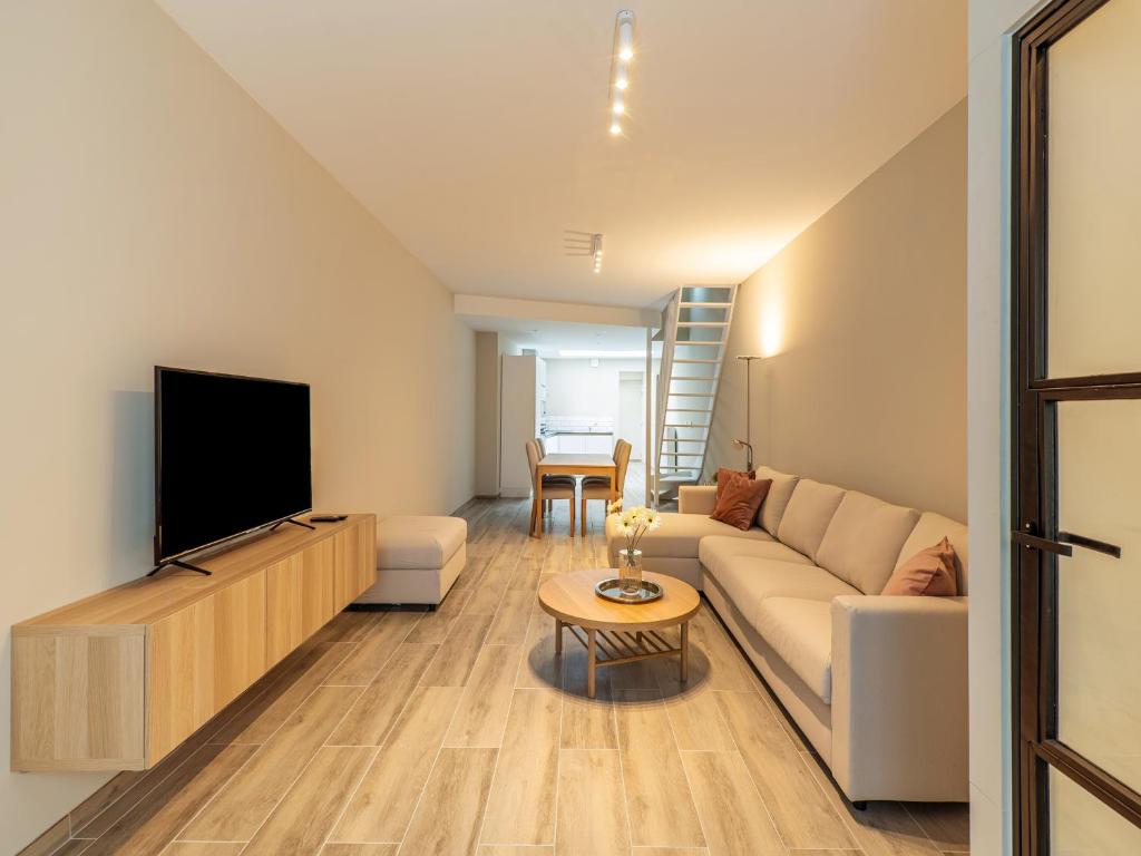 uma sala de estar com um sofá e uma televisão em Weststraat 116 em Blankenberge