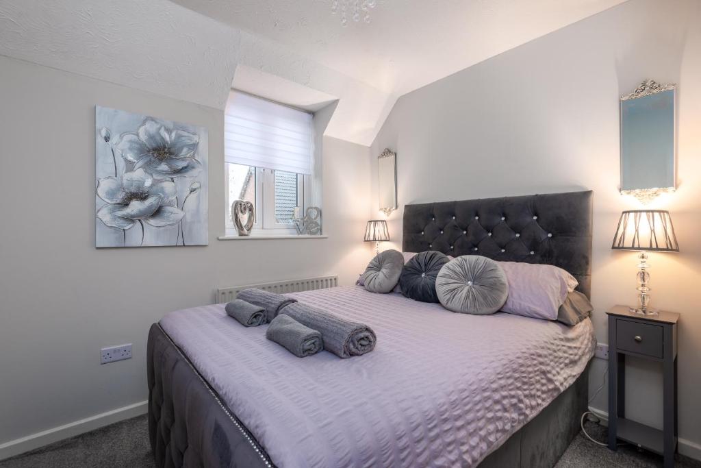 a bedroom with a large bed with pillows on it at WORCESTER Fabulous Cherry Tree Mews self check in dogs welcome , 2 double bedrooms ,super fast Wi-Fi, with free off road parking for 2 vehicles near Royal Hospital and woodland walks in Worcester