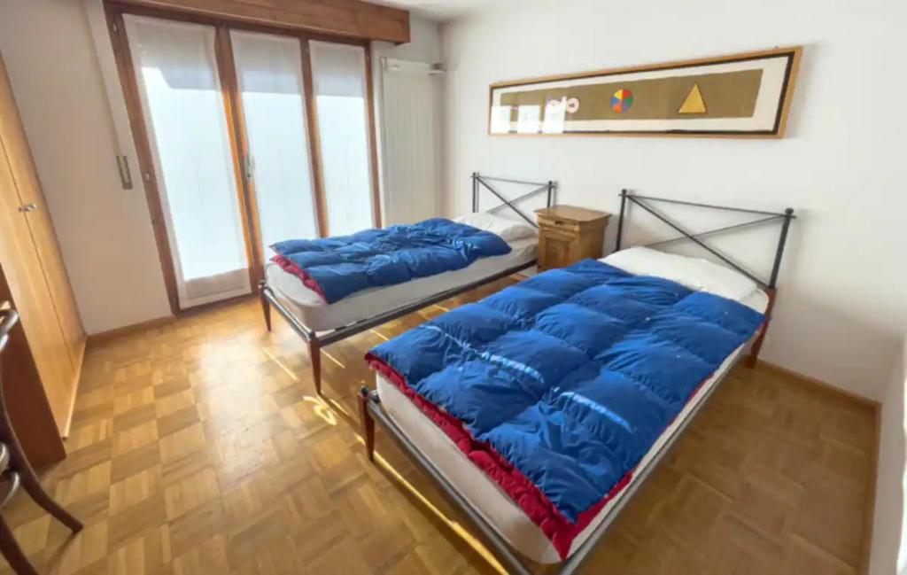 um quarto com 2 camas e almofadas azuis em tHE Eagle Nest Duplex - Your Mountain Retreat em Chalais