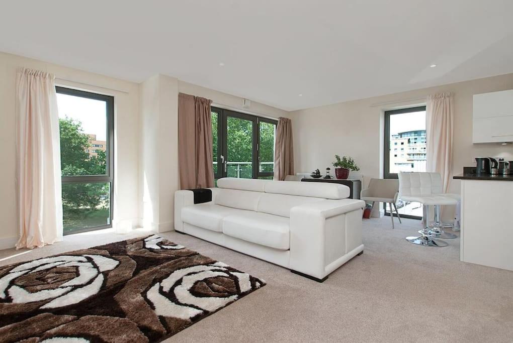un soggiorno bianco con divano bianco e tappeto di Bright 2BR wParking & Rooftop Garden, Battersea a Londra