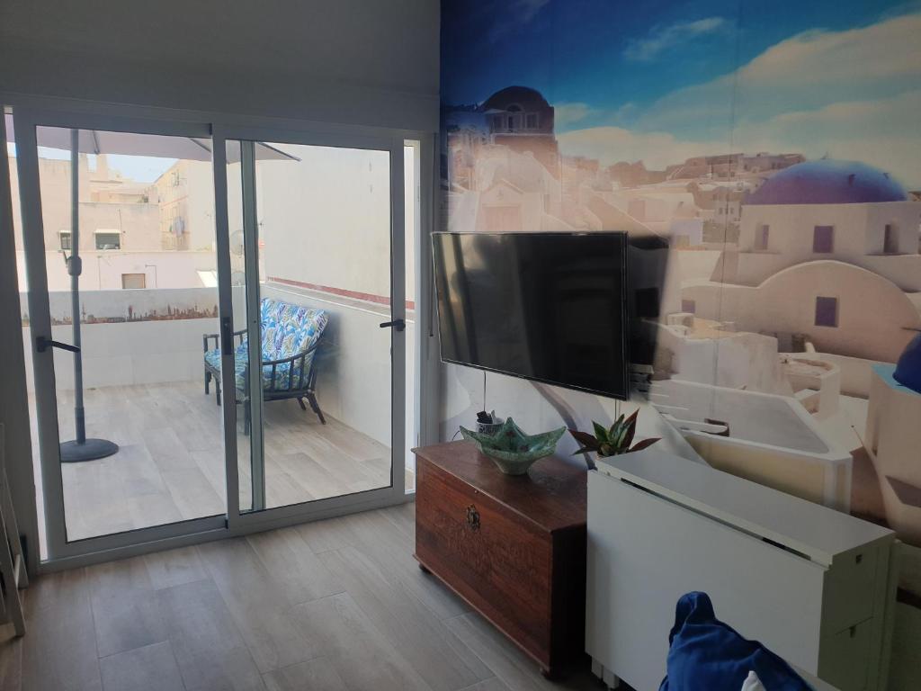 a living room with a flat screen tv and a balcony at CALTERR - Loft con Terraza privada, Wifi, Recién reformado in Torremolinos