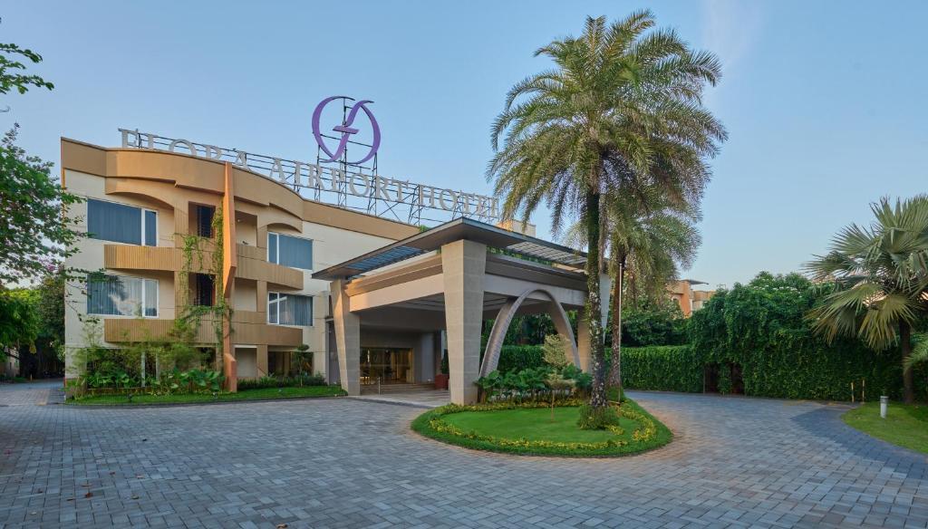 un bâtiment avec un palmier en face dans l'établissement Flora Airport Hotel and Convention Centre Kochi, à Nedumbassery