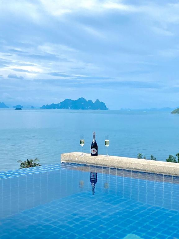 a bottle of wine and two glasses in a swimming pool at Stunning 5 bedrooms Villa with Panoramic Sea View in Por Bay