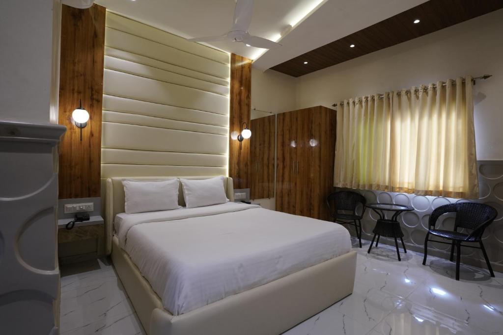 a bedroom with a bed and a table and chairs at Palm Springs Beach Resort - Gorai in Mumbai