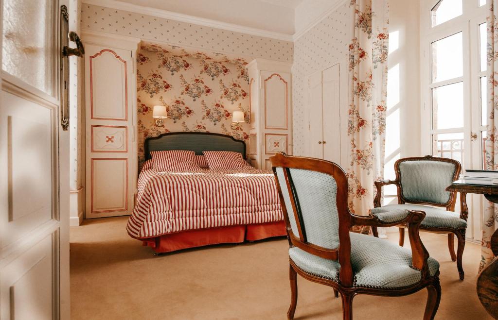 - une chambre avec un lit et deux chaises dans l'établissement Château de Castel Novel Boutique Hôtel, à Varetz