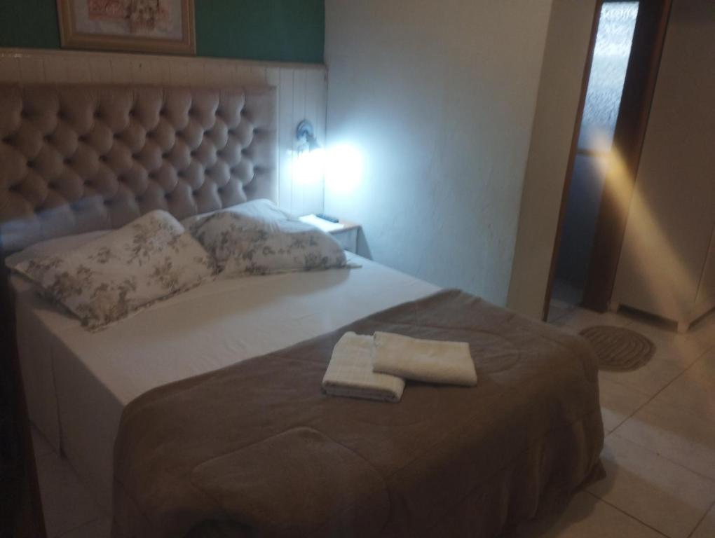 a bedroom with a large bed with two towels on it at Pousada águia da serra in Gramado