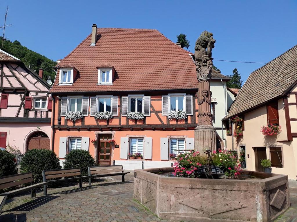 um edifício com uma estátua e uma fonte em frente em Gîte chez Val et Mat em Ribeauvillé