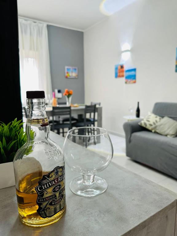 a bottle of whiskey and a wine glass on a table at Ferdirisa Vesuvio Home&Garden in San Giorgio a Cremano