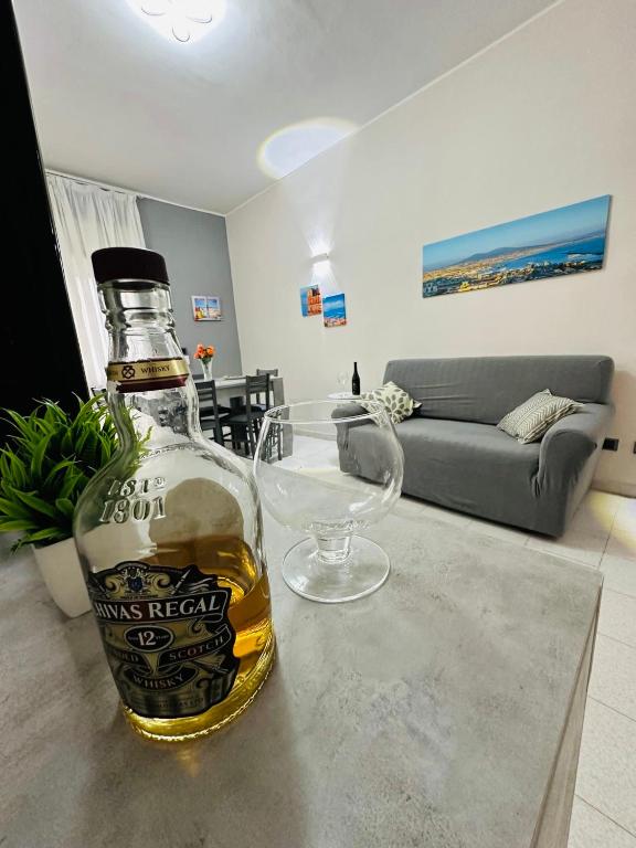 a bottle of whisky sitting on a table in a living room at Ferdirisa Vesuvio Home&Garden in San Giorgio a Cremano