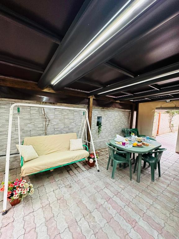 a patio with a swing and a table and a couch at Ferdirisa Vesuvio Home&Garden in San Giorgio a Cremano