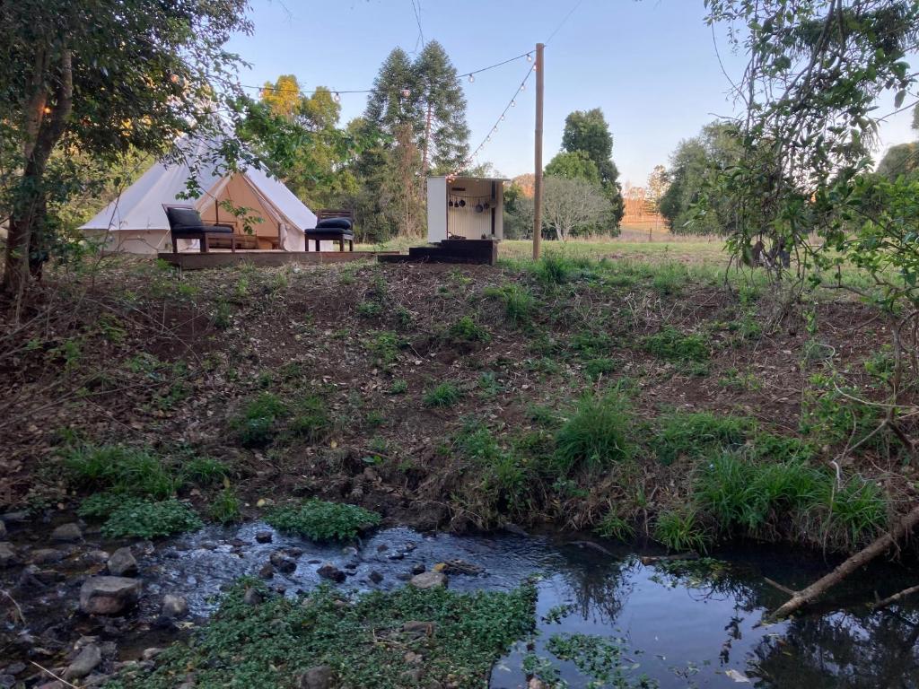 ein Zelt und ein Bach vor einem Feld in der Unterkunft Tent destroyed sorry 