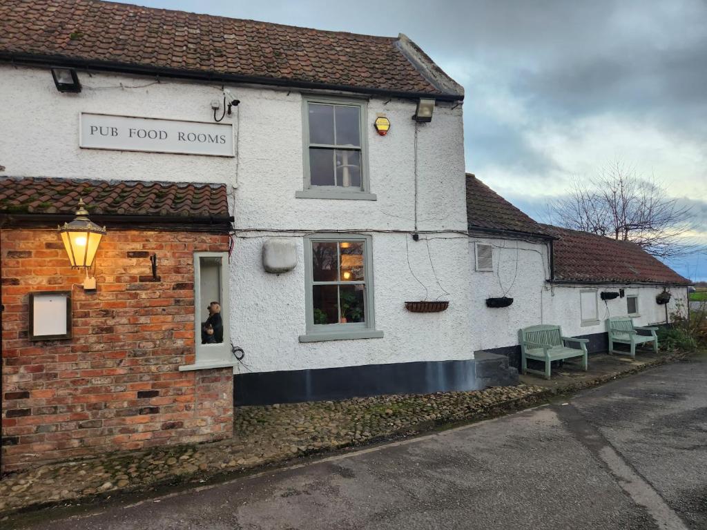 een gebouw met twee groene banken erbuiten bij Red Lion Inn & Motel in York