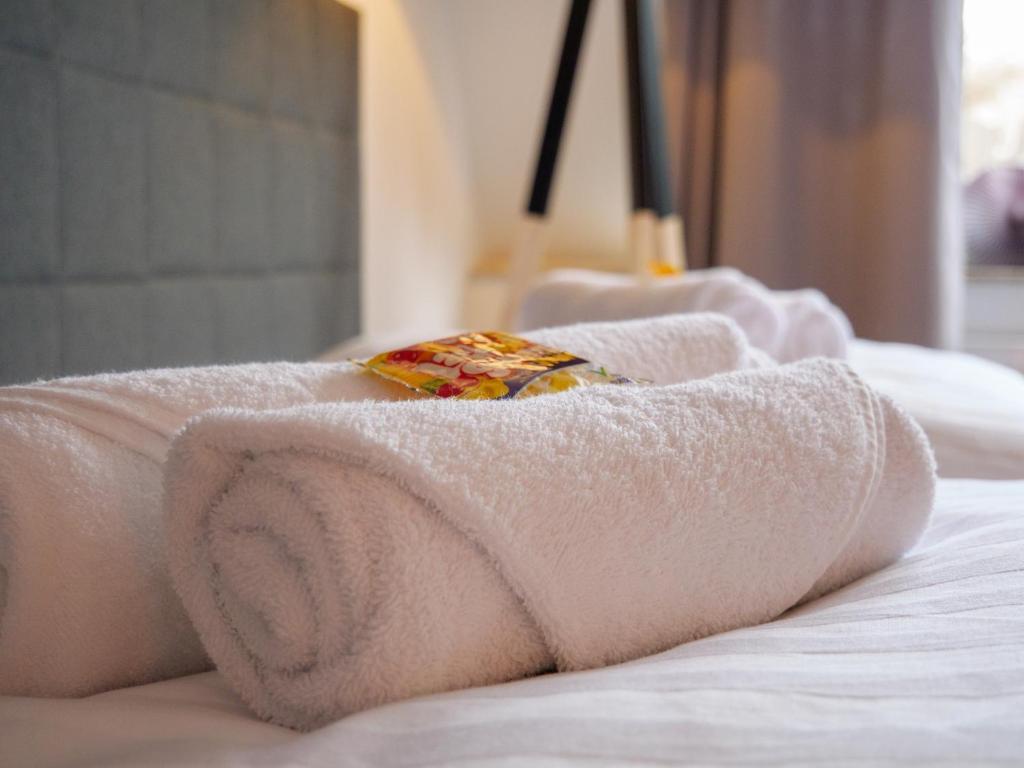 a pile of towels on a bed at AMAO-Green I 90qm I Zentrum I Maisonette I Dachterrasse I King-Size Boxspringbetten I EuropaPark in Lahr