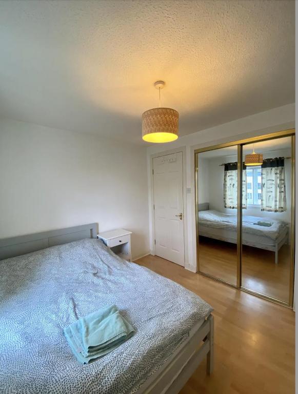 um quarto com uma cama e um espelho grande em cozy room in Edinburgh em Edinburgo