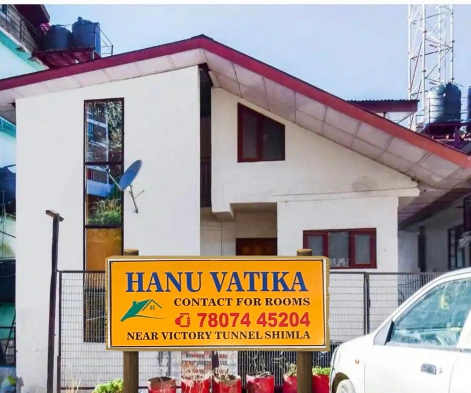 una casa con un cartel delante de ella en HANU VATIKA The FAMILY CHOICE, en Shimla