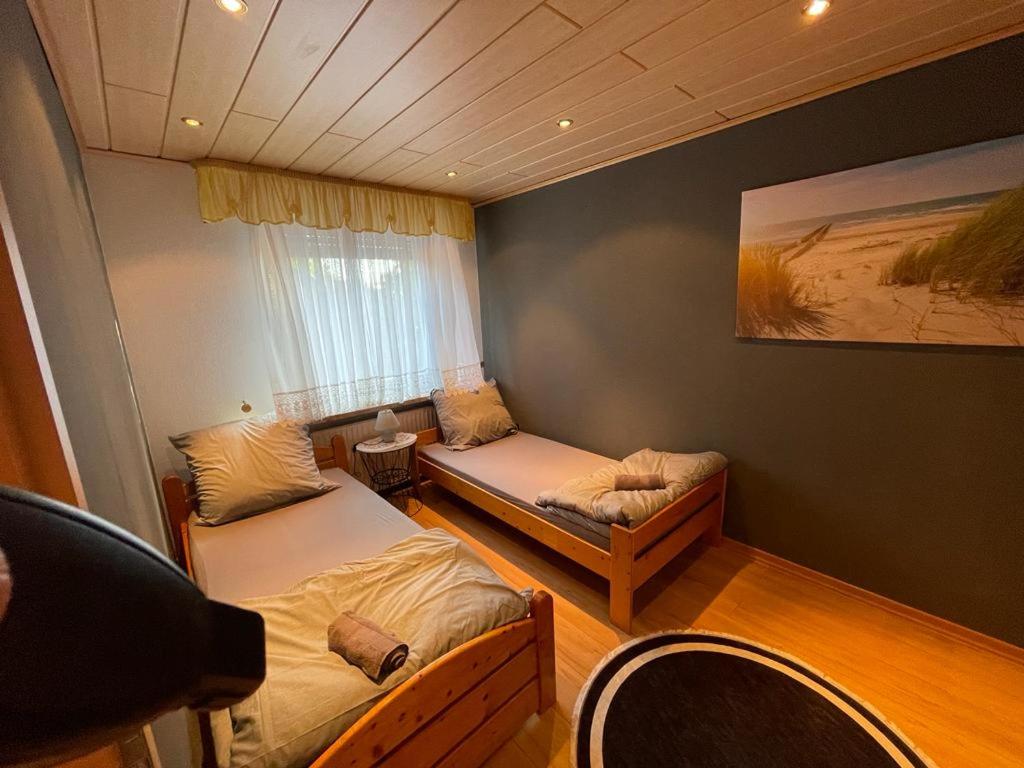 Habitación pequeña con 2 camas y ventana en Fairbooking24private Apartments Nbg Exhibition Ground Room Agancy, en Núremberg