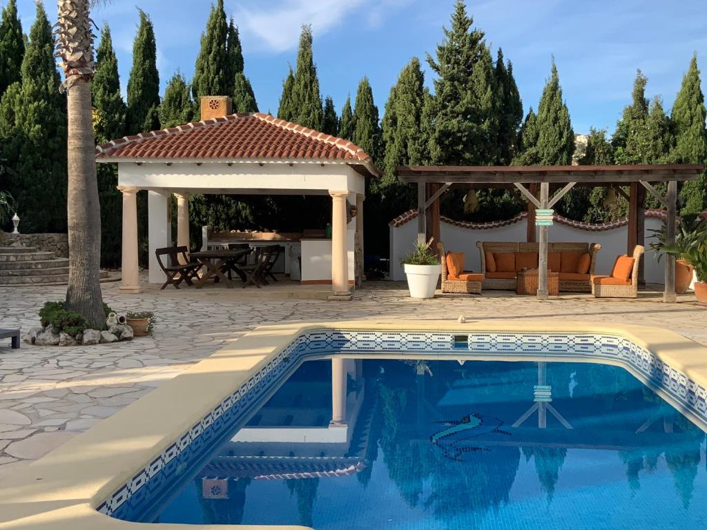 una piscina en un patio trasero con cenador en Villa coup de coeur Costa Blanca, en Pedreguer