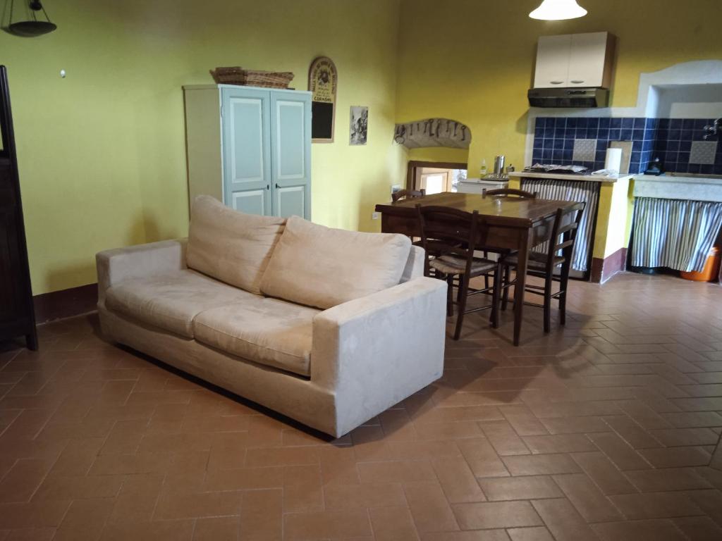 een woonkamer met een bank en een tafel bij La casa di Iara in Pitigliano