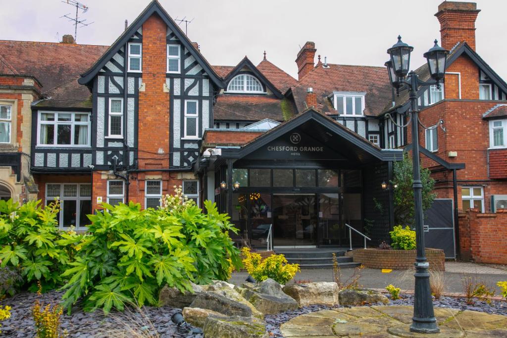 um antigo edifício preto e branco com uma luz de rua em Chesford Grange Hotel em Kenilworth