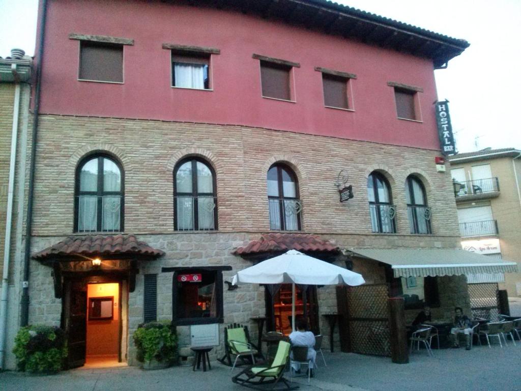 a large brick building with an umbrella in front of it at Hostal Suetxe in Los Arcos