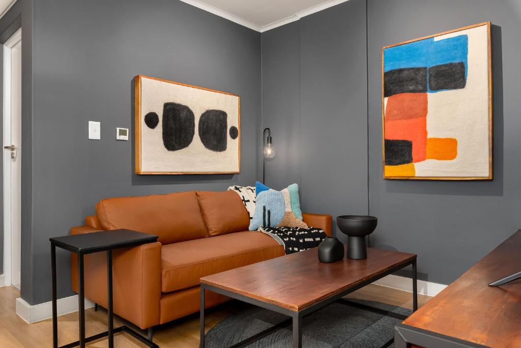 a living room with a couch and some paintings at The Tokyo 307 in Cape Town