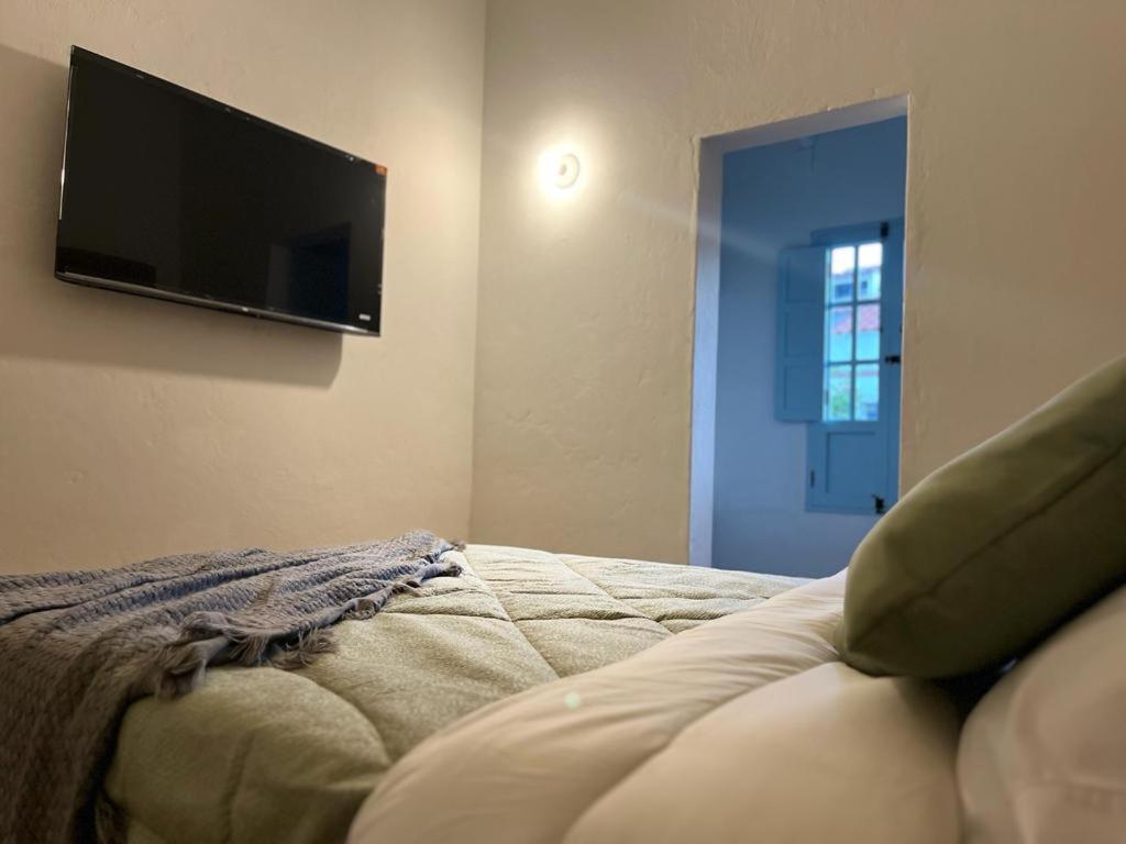 a bedroom with a flat screen tv on the wall at Encanto Azul en Villa in Villa de Leyva