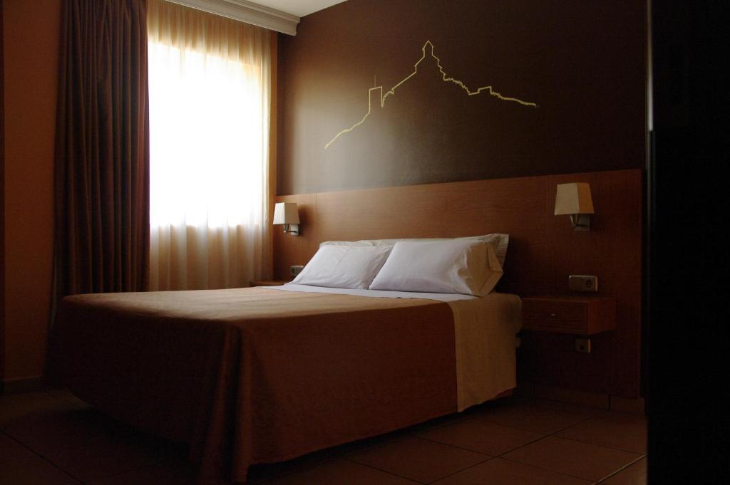 a bedroom with a bed with a lightning chart on the wall at Hotel Solsona Centre in Solsona