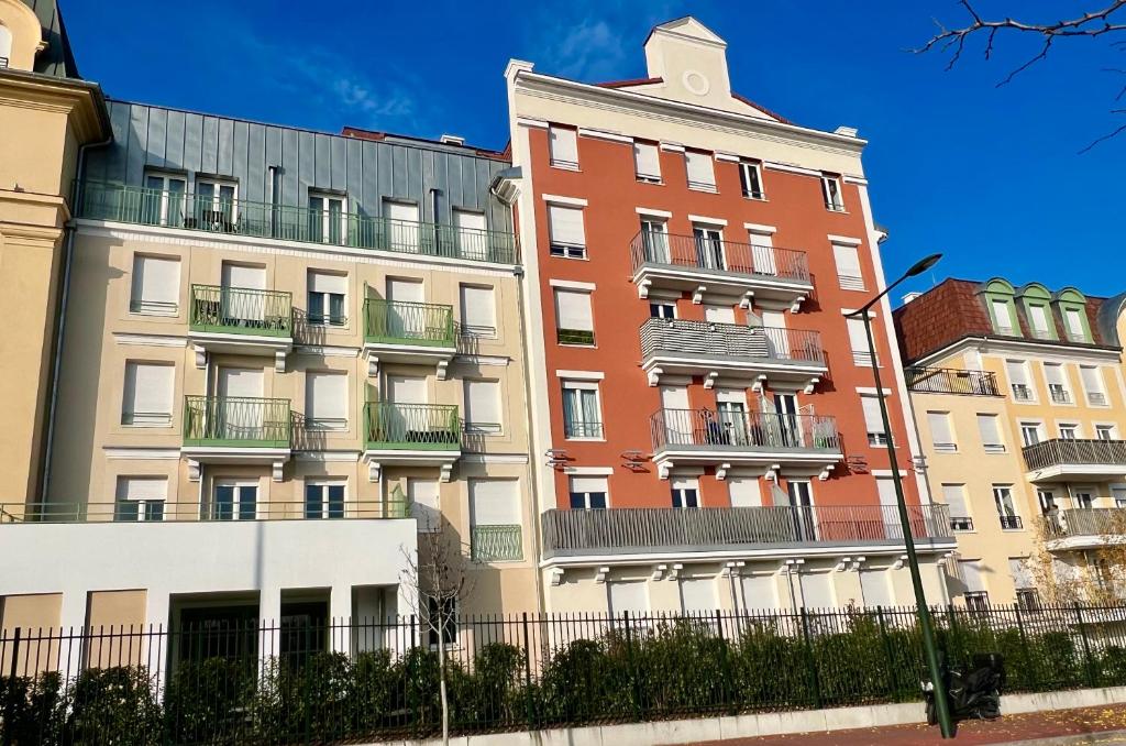 a building with balconies on the side of it at Studio cosy - 15 minutes from Paris and CDG Airport in Le Blanc-Mesnil