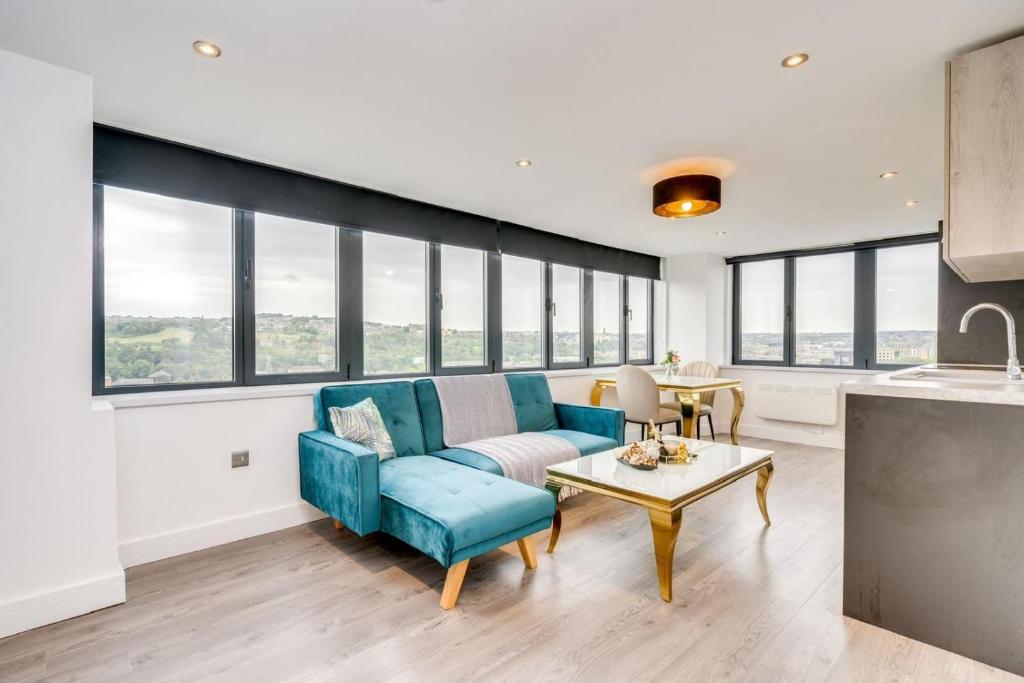 uma sala de estar com um sofá azul e uma mesa em ENTERPRISE APARTS em Bradford