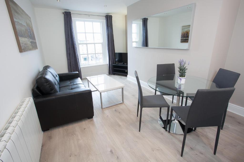 a living room with a glass table and a couch at Temple Bar Essex Apartments in Dublin