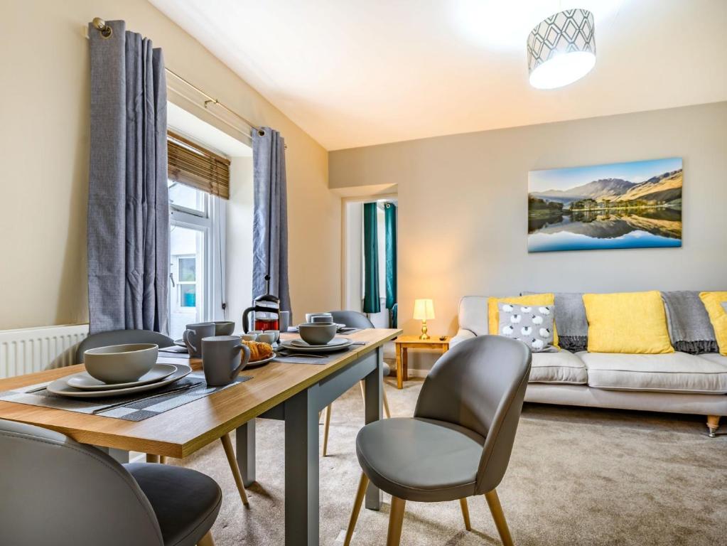 een woonkamer met een tafel en stoelen en een bank bij 2 Bed in Cockermouth 87481 in Cockermouth