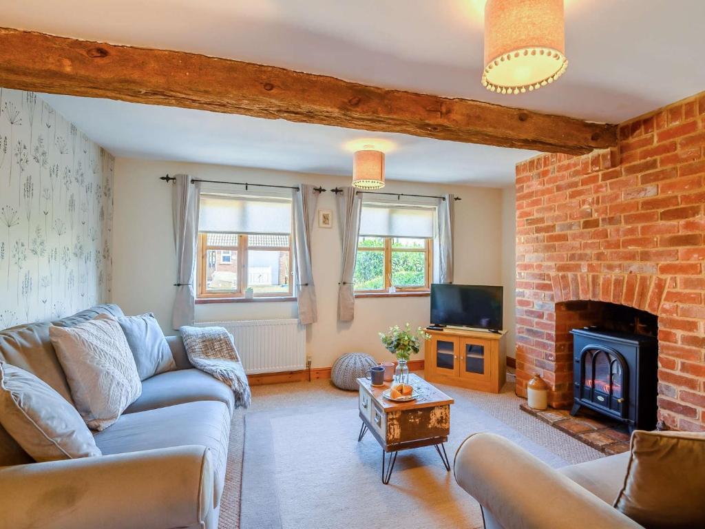 - un salon avec un canapé et une cheminée dans l'établissement 3 bed property in Mattishall 88569, à Yaxham