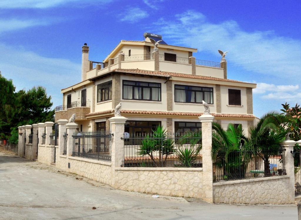 a large house with a fence in front of it at B&B Nicole in Palma di Montechiaro