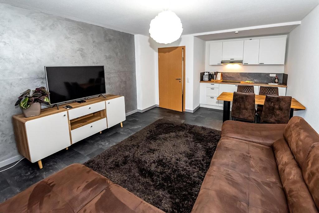 een woonkamer met een bank en een tv en een keuken bij Apartment Dresden 2OG links in Dresden