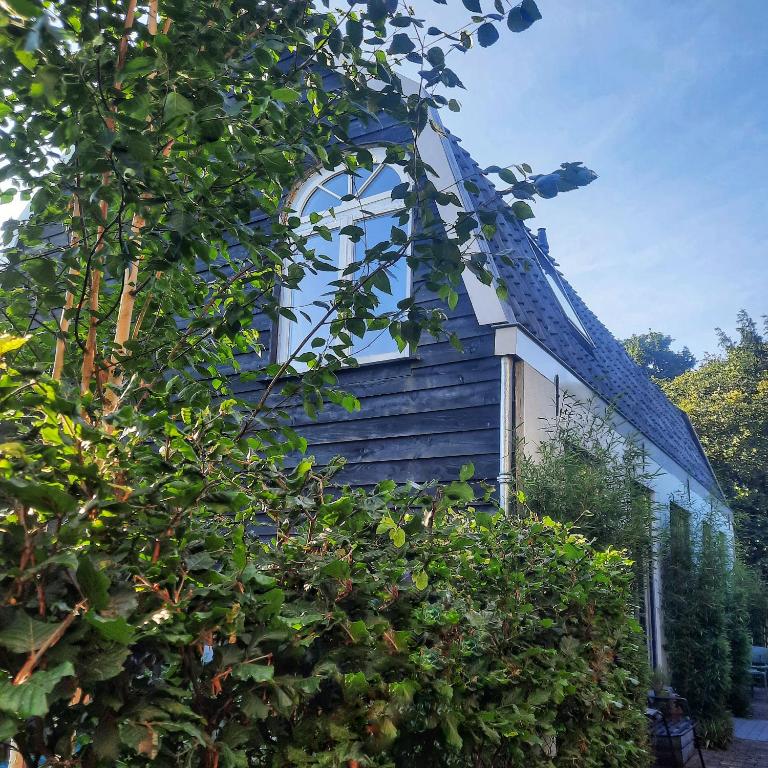 a blue and white building with a tree at Inn the Green in Zeist