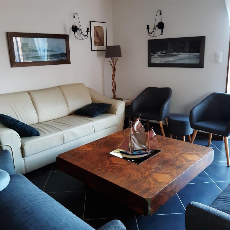 un salon avec un canapé et une table basse dans l'établissement Les moussaillons, Les gîtes de Tréguennec, à Tréguennec