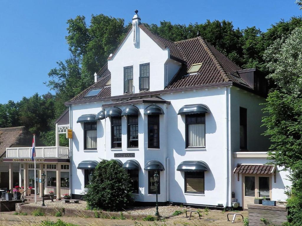 une maison blanche avec un toit marron dans l'établissement Mare Sanat, à Wijk aan Zee