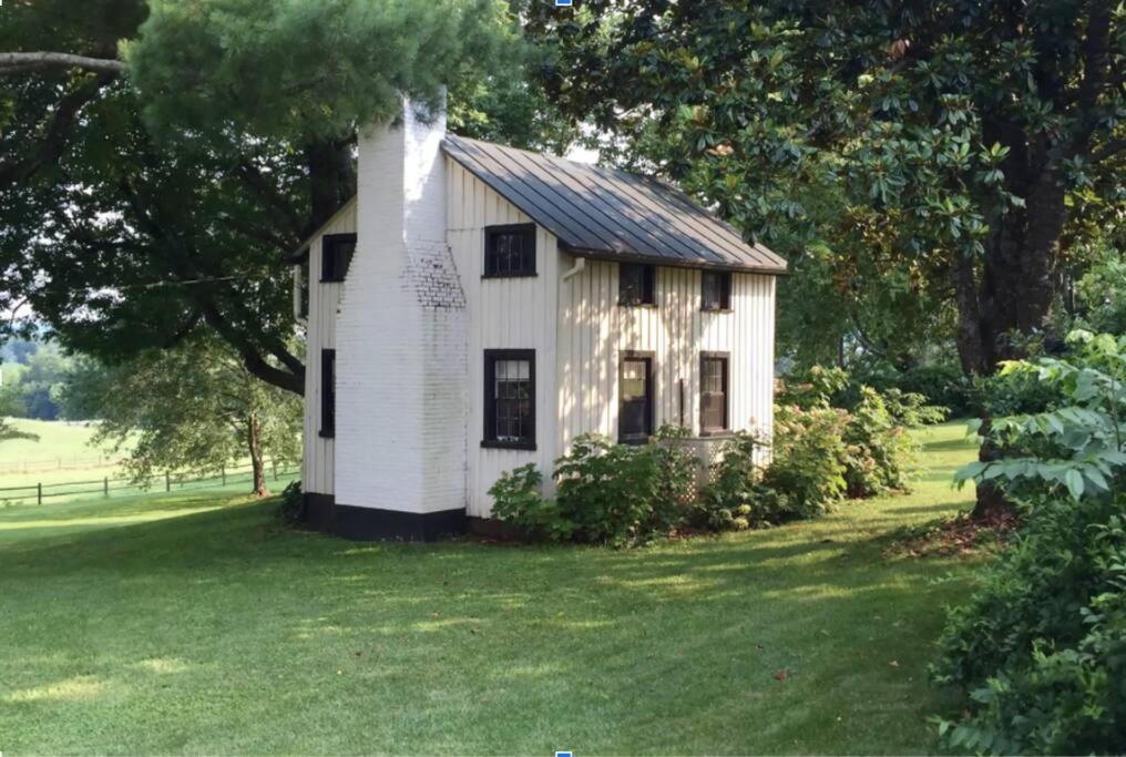 une petite maison blanche dans un champ d'herbe dans l'établissement Charming & Rustic Bloomingdale Cottage w/views, 