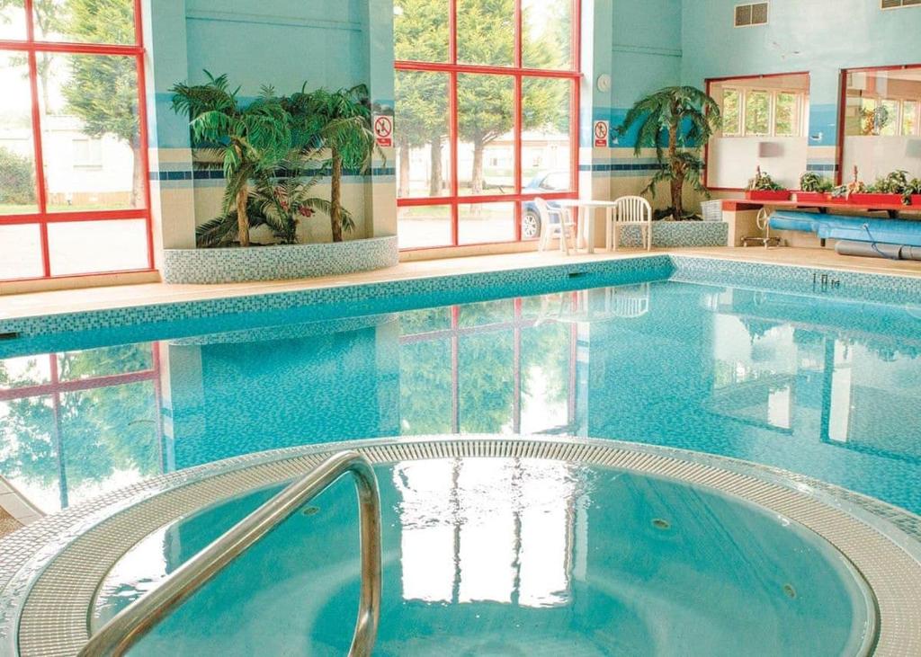 a swimming pool with a hot tub in a building at Thurston Manor in Innerwick