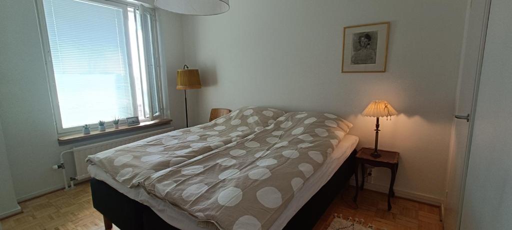 a bedroom with a bed and a lamp on a table at Cozy renovated flat in Kajaani center (alv. vähennyskelpoinen) in Kajaani