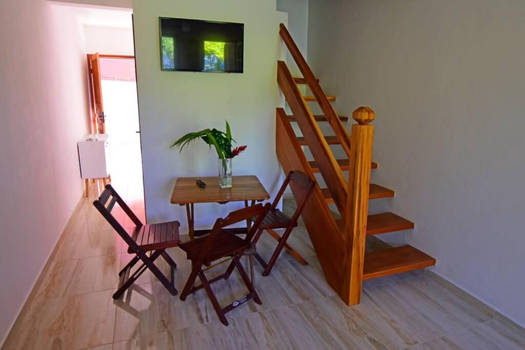 een kamer met een tafel en stoelen en een trap bij Casa Ramildes Paraty flat 5 in Paraty