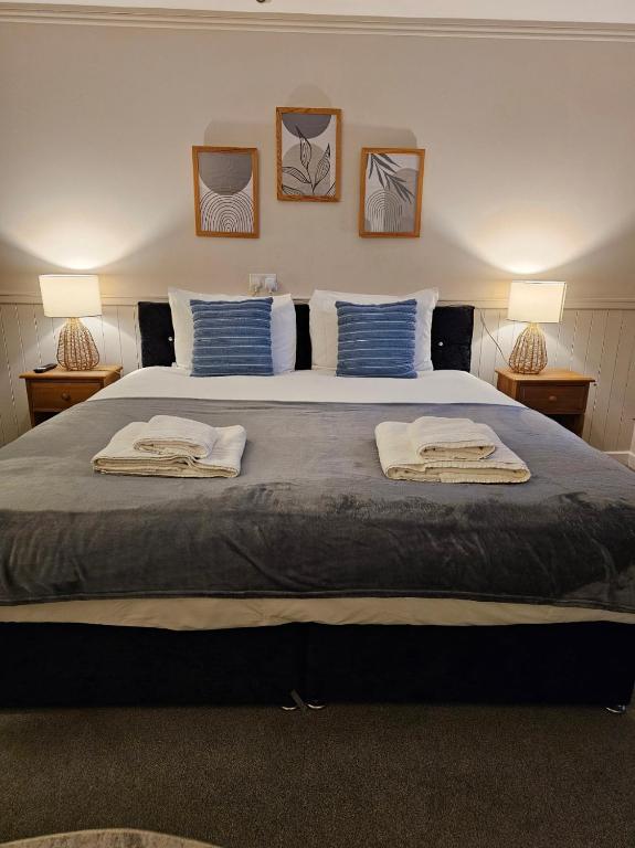 a bedroom with a large bed with two towels on it at Dog and Partridge Inn in Calne